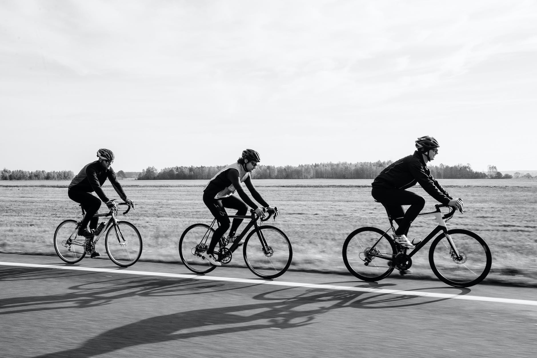 grayscale photo of people riding bicyle
